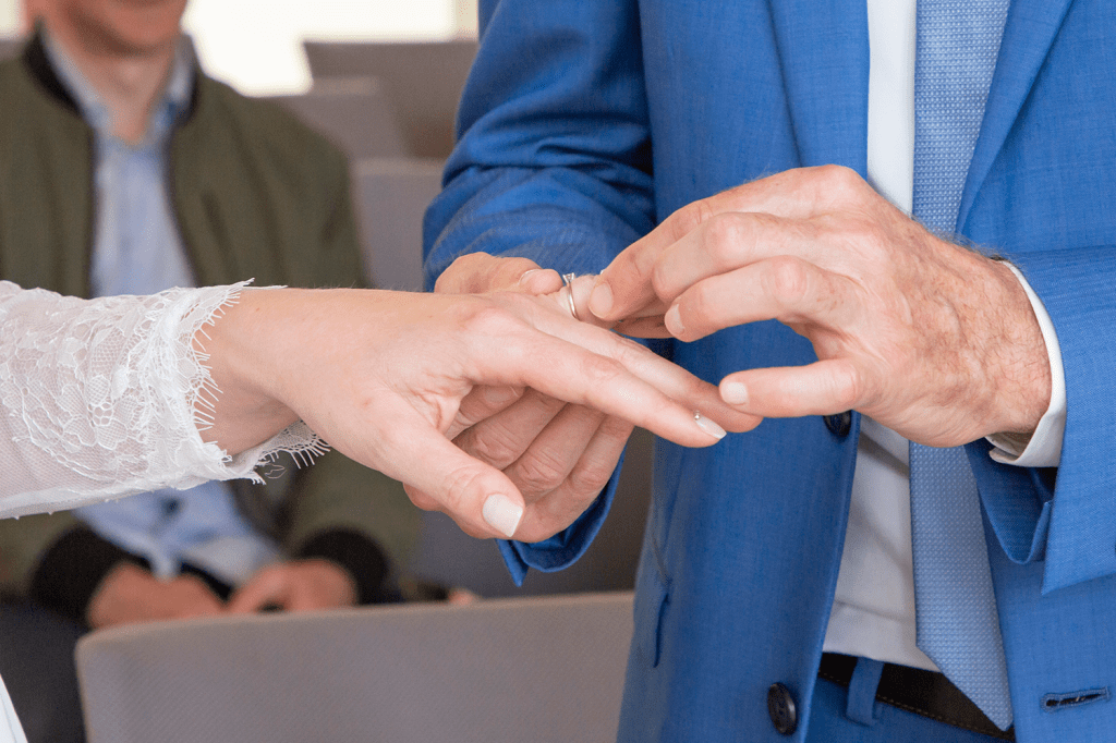 photo du marié passant l'alliance au doigt de sa femme