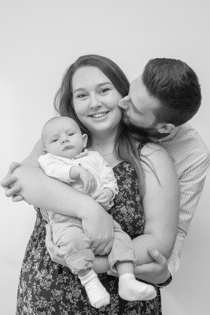 photo noir et blanc des parents avec bébé dans les bras de maman 