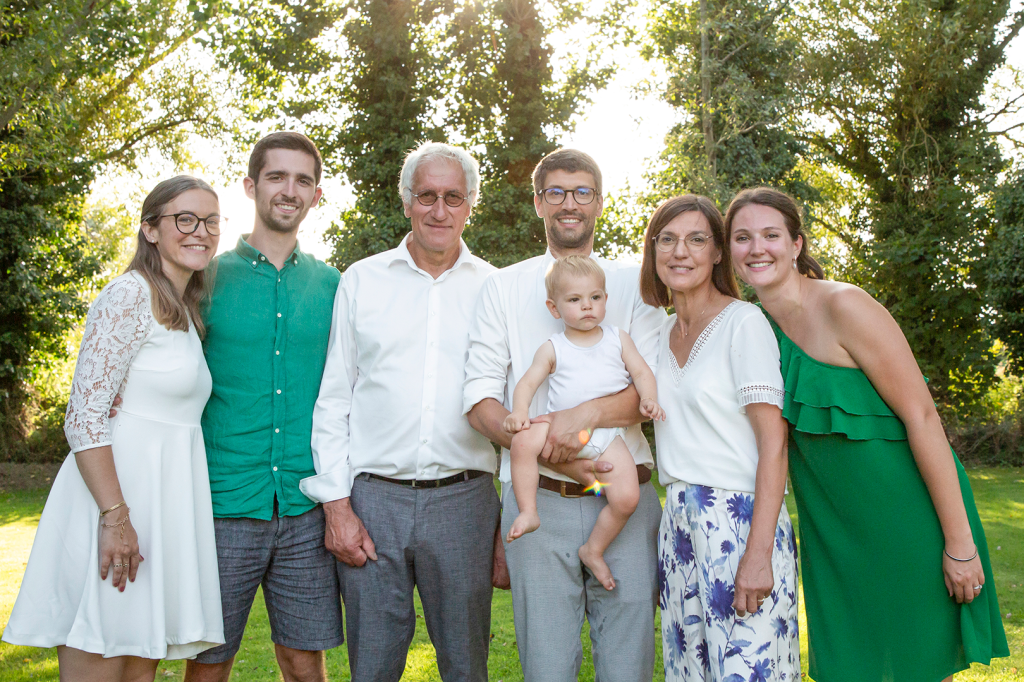 photo de famille dans un jardin avec les parents, grands parents et le bébé