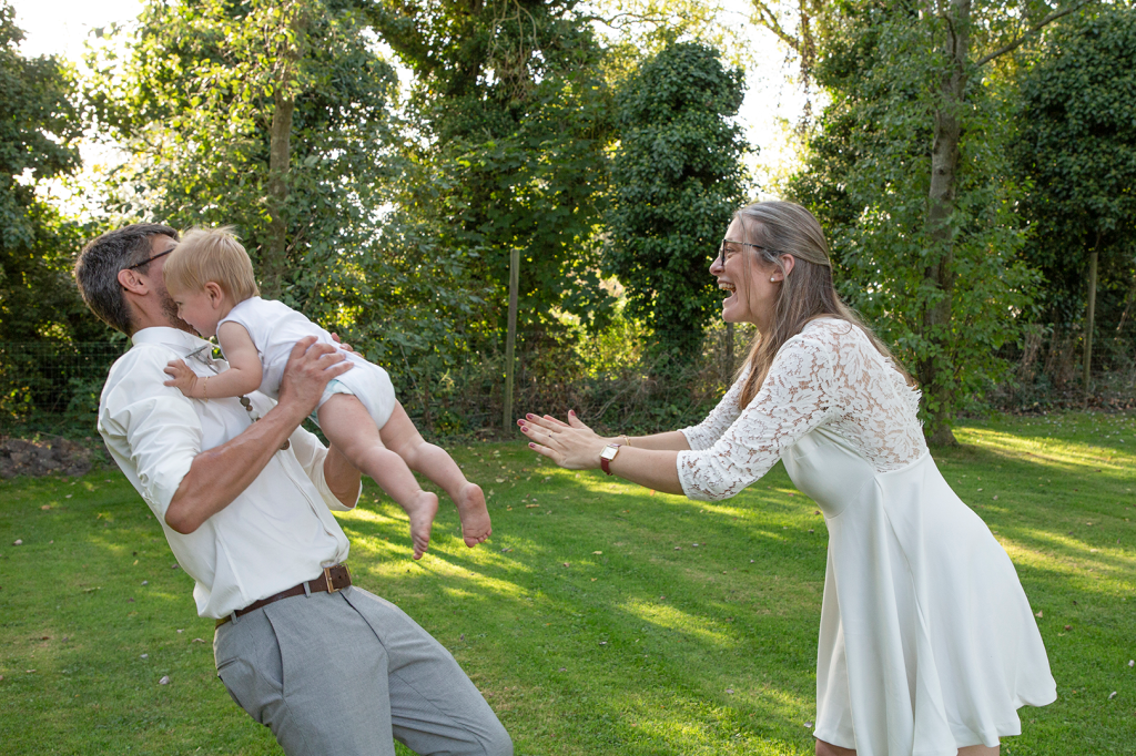 photos de deux parents jouant avec leur fils dans un jardin