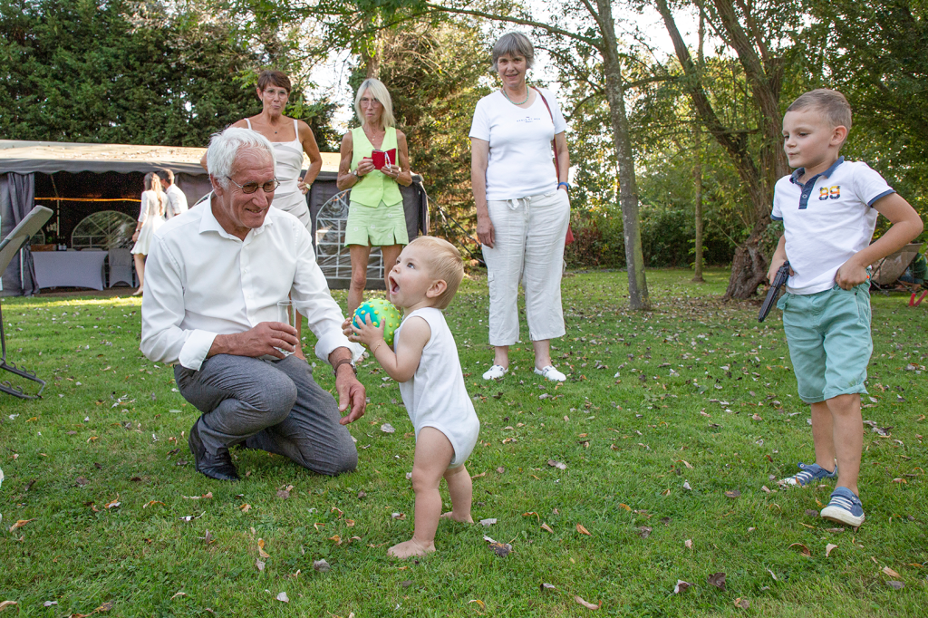 photo d'un enfant jouant avec son grand père dans le jardin