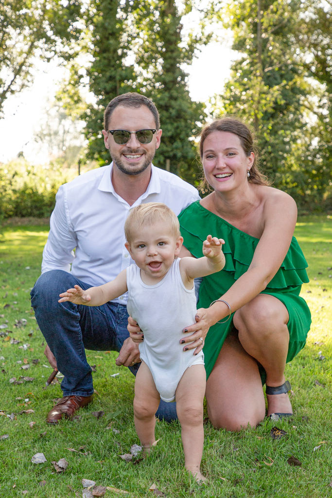photo d'un couple avec leur enfant marchant vers l'objectif dans un jardin