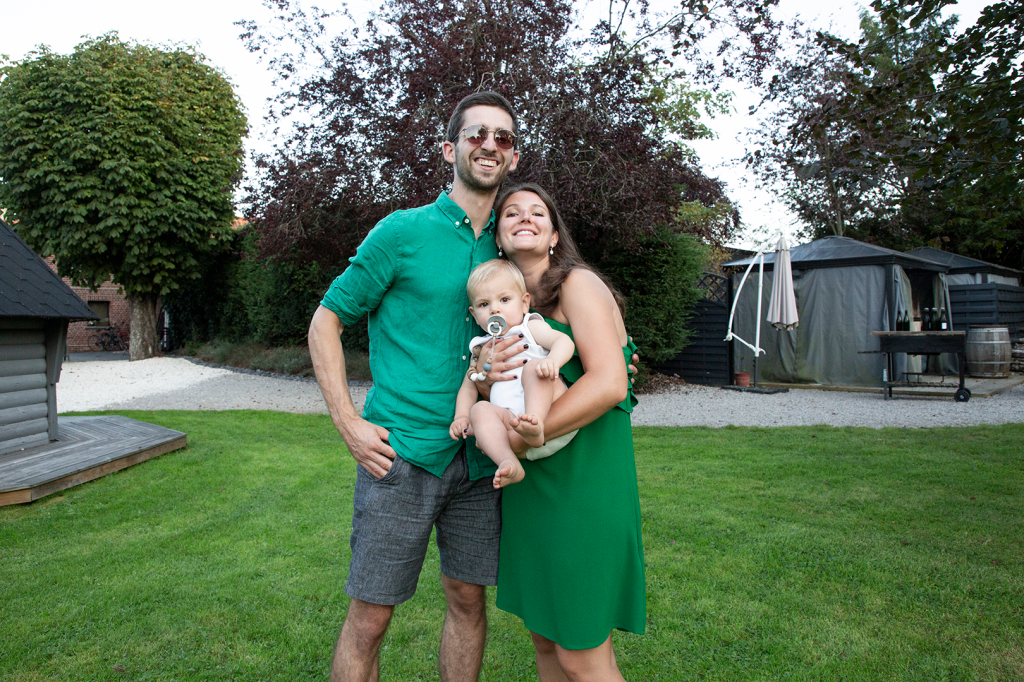 photo d'un couple tenant leur enfant à bras dans un jardin