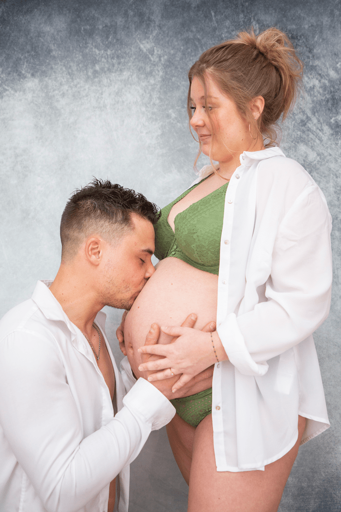 Photo de maternité, le papa embrasse le ventre de la maman 