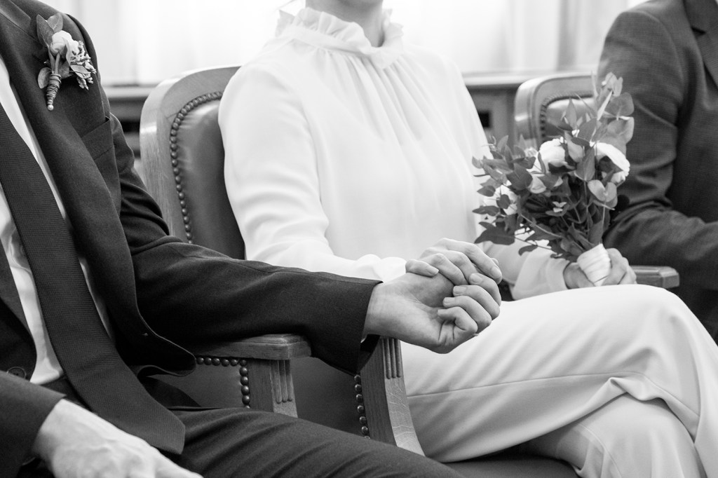 photo des main des mariés avec un bouquet noir et blanc
