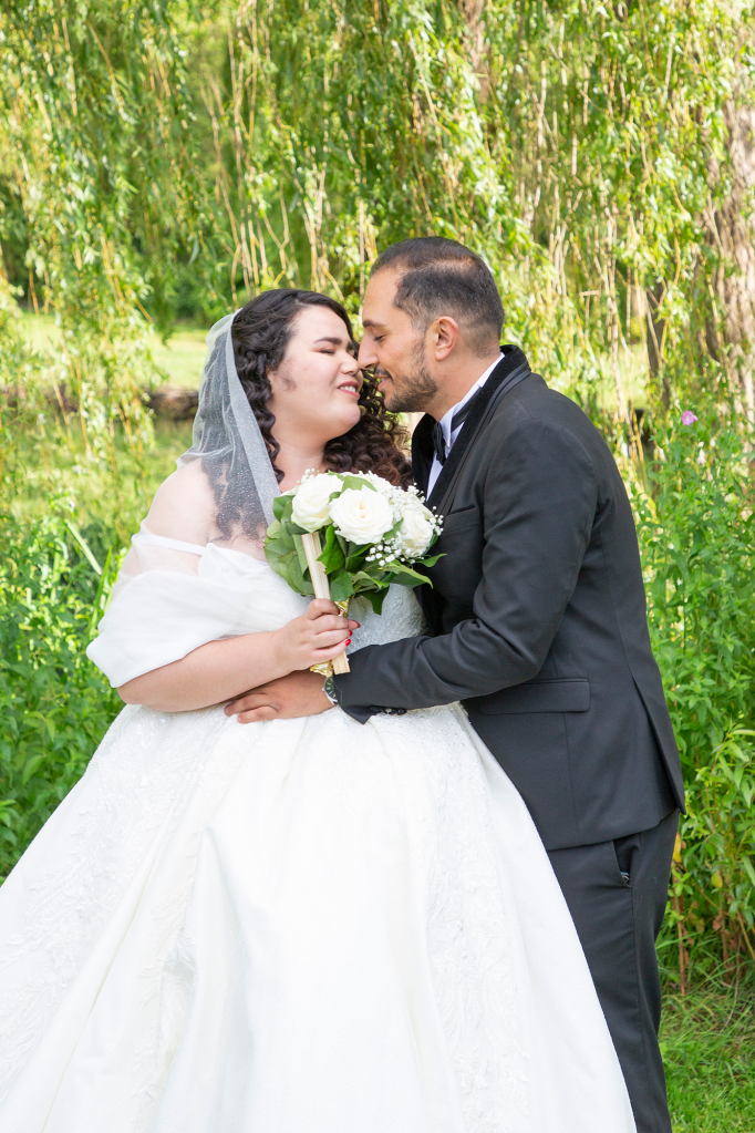 photo des mariés s'embrassant au parc