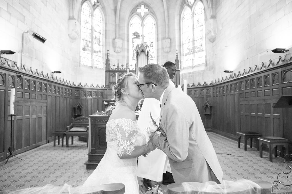 Photo des mariés s'embrassant à l'église noir et blanc